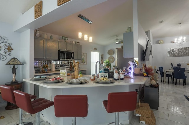 2442 Foxhollow Rd, Tavares, FL 32778 - kitchen with light countertops, visible vents, a kitchen bar, appliances with stainless steel finishes, and pendant lighting