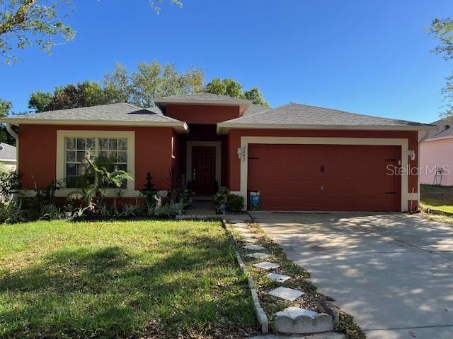 2442 Foxhollow Rd, Tavares, FL 32778 - view of front of property with a front lawn, driveway, and a garage