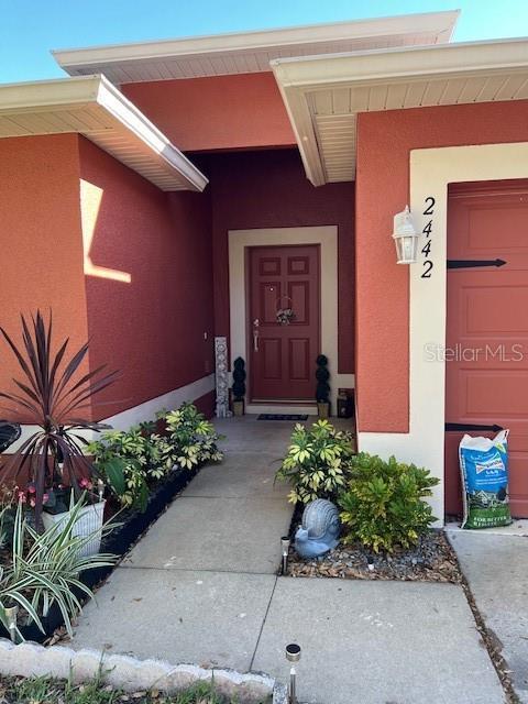 2442 Foxhollow Rd, Tavares, FL 32778 - view of exterior entry with stucco siding
