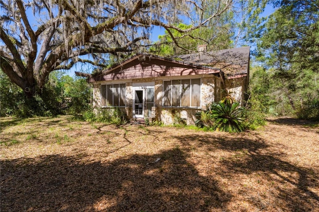 801 Kilgore St, Wildwood, FL 34785 - back of house with stone siding and a sunroom