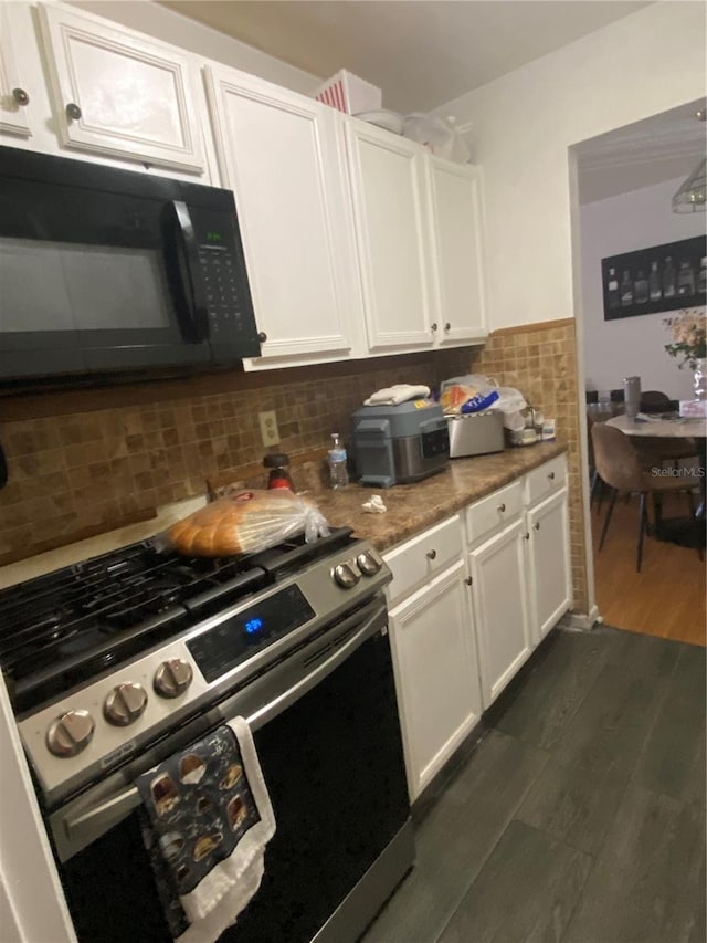 kitchen with dark wood-style flooring, black microwave, stainless steel gas stove, and white cabinets