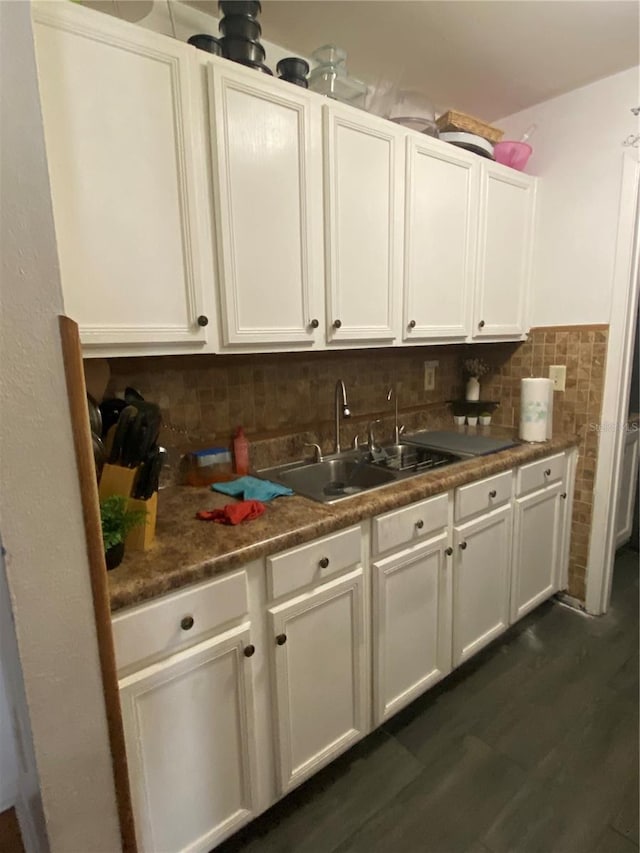 kitchen featuring decorative backsplash, dark wood-style flooring, white cabinetry, and a sink