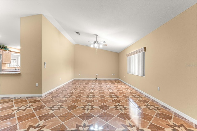 unfurnished room with a wealth of natural light, baseboards, a ceiling fan, and vaulted ceiling