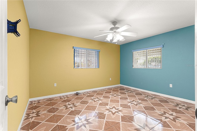 spare room featuring baseboards, a textured ceiling, and a ceiling fan