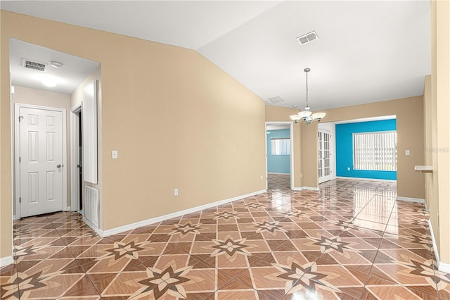 spare room featuring lofted ceiling, a notable chandelier, baseboards, and visible vents