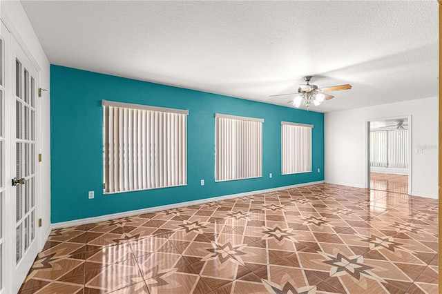 unfurnished room featuring french doors, baseboards, a textured ceiling, and ceiling fan