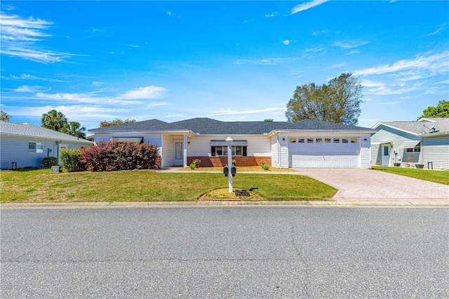 ranch-style home with driveway, a front yard, and an attached garage