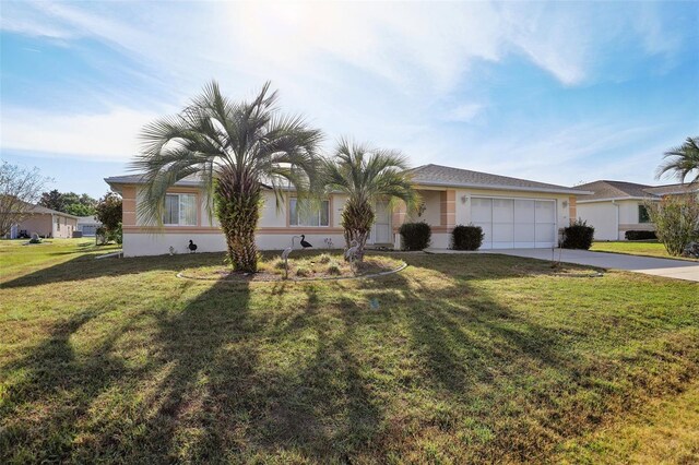 view of front facade featuring a front yard, stucco siding, concrete driveway, and a garage