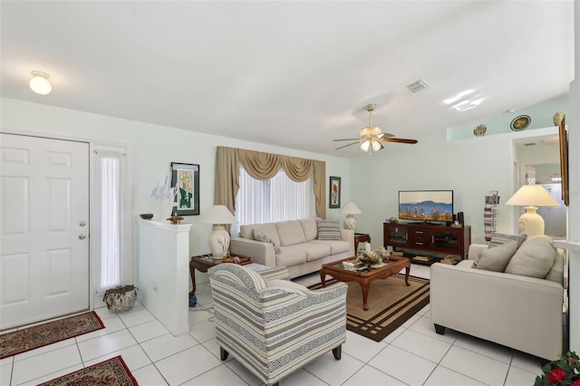 living area with light tile patterned flooring, ceiling fan, visible vents, and vaulted ceiling