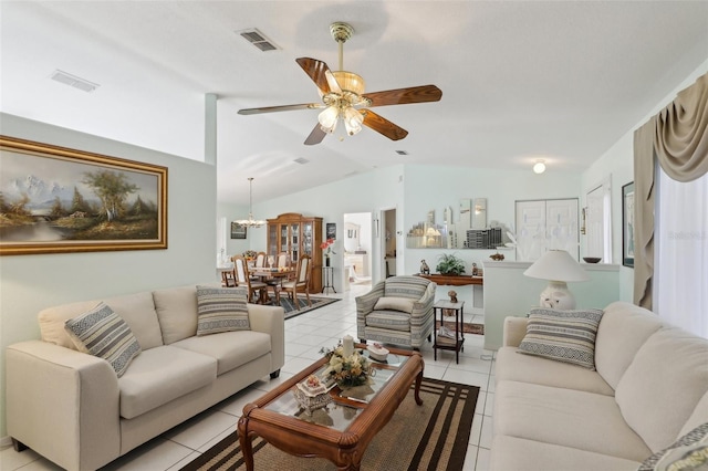 living area with light tile patterned flooring, ceiling fan with notable chandelier, visible vents, and vaulted ceiling