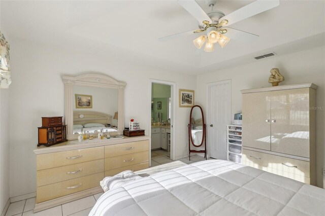 bedroom featuring a ceiling fan, ensuite bath, light tile patterned floors, baseboards, and visible vents