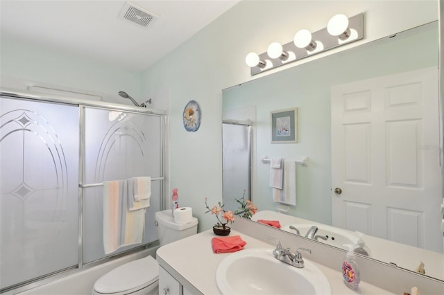 full bath featuring visible vents, bath / shower combo with glass door, toilet, and vanity
