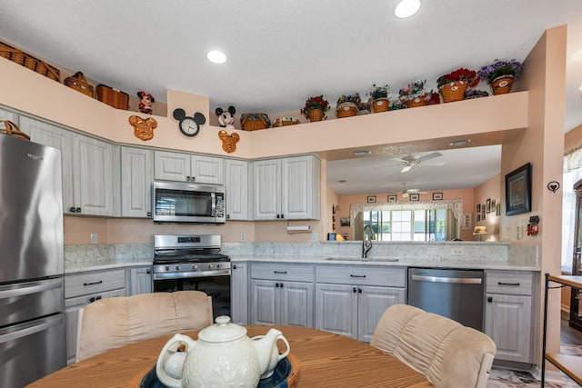 kitchen with a sink, gray cabinetry, stainless steel appliances, ceiling fan, and recessed lighting
