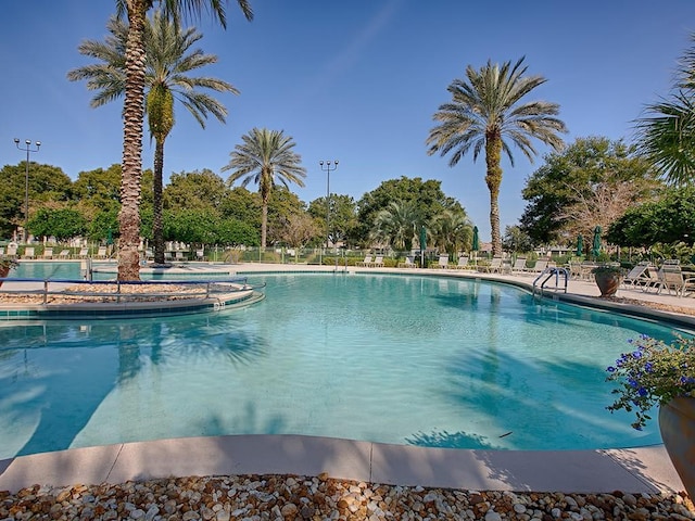 community pool with a patio and fence