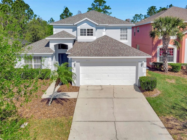 traditional-style house featuring a front yard, stucco siding, a shingled roof, concrete driveway, and a garage