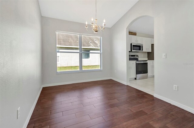 unfurnished dining area with an inviting chandelier, light wood-style flooring, arched walkways, and lofted ceiling