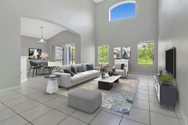 living room with a high ceiling, light tile patterned floors, baseboards, and arched walkways
