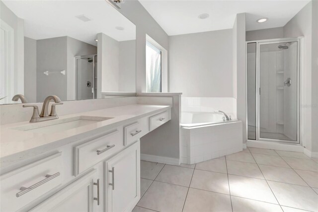 full bathroom with tile patterned flooring, a shower stall, vanity, and a garden tub