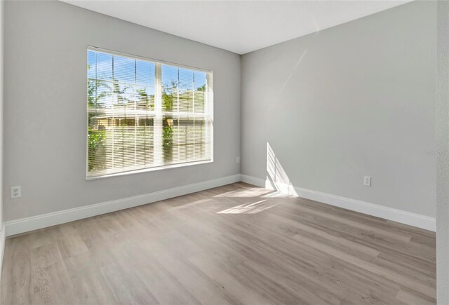 unfurnished room with baseboards and wood finished floors
