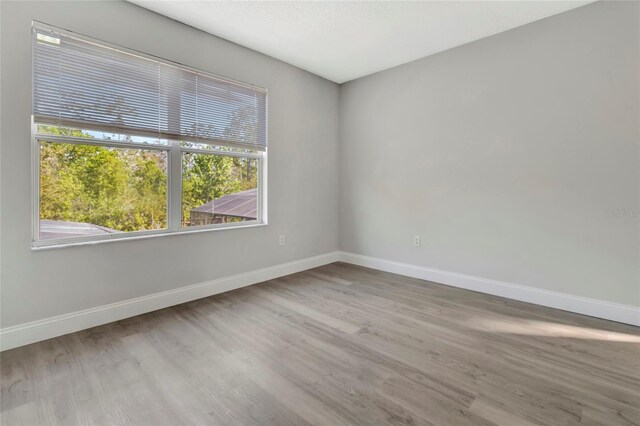 unfurnished room with wood finished floors and baseboards