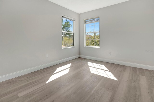 unfurnished room featuring light wood-type flooring and baseboards