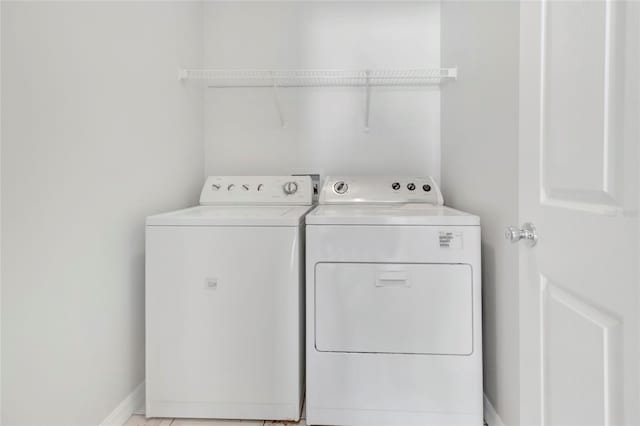 laundry room featuring laundry area, baseboards, and washing machine and clothes dryer