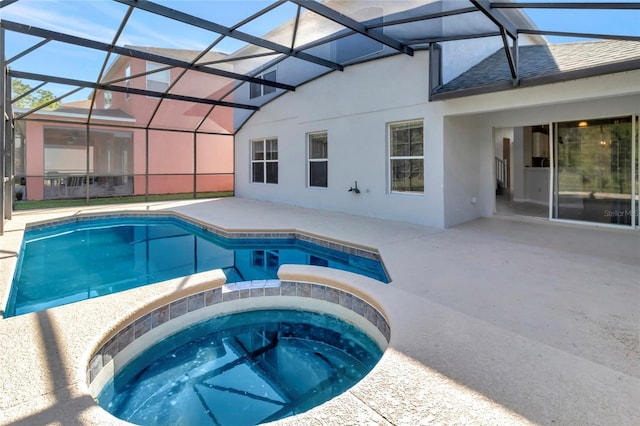 view of swimming pool with glass enclosure, a patio, and a pool with connected hot tub