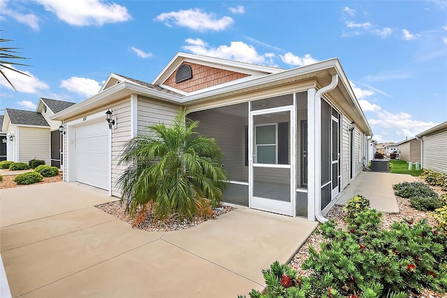 3557 Cochran St, The Villages, FL 32163 - view of front of house with concrete driveway, a sunroom, and an attached garage