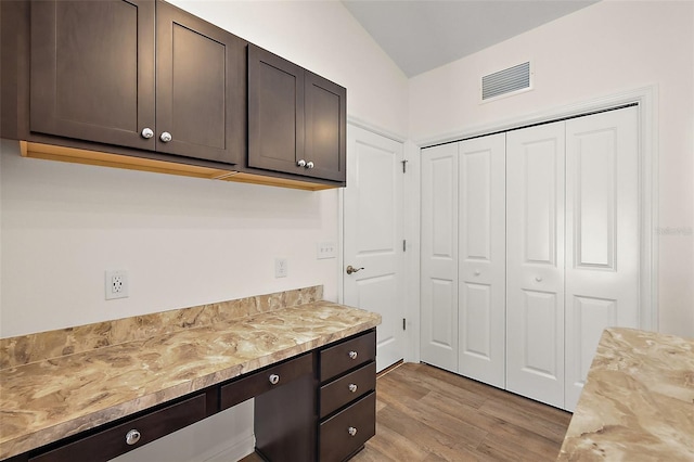 3557 Cochran St, The Villages, FL 32163 - kitchen with dark brown cabinetry, visible vents, vaulted ceiling, and light wood finished floors