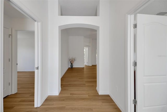 2433 Tamarindo Dr, The Villages, FL 32162 - hallway with light wood-type flooring, arched walkways, baseboards, and visible vents