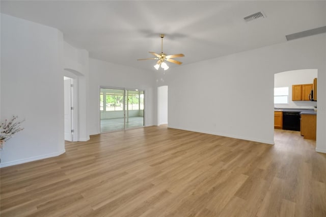 2433 Tamarindo Dr, The Villages, FL 32162 - unfurnished living room with visible vents, arched walkways, light wood-style flooring, and ceiling fan