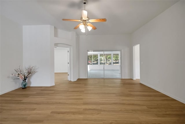 2433 Tamarindo Dr, The Villages, FL 32162 - spare room featuring arched walkways, baseboards, ceiling fan, and light wood-type flooring