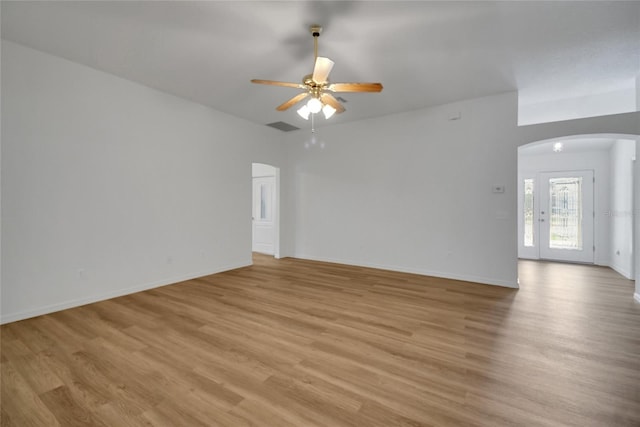 2433 Tamarindo Dr, The Villages, FL 32162 - unfurnished room with light wood finished floors, baseboards, visible vents, arched walkways, and ceiling fan