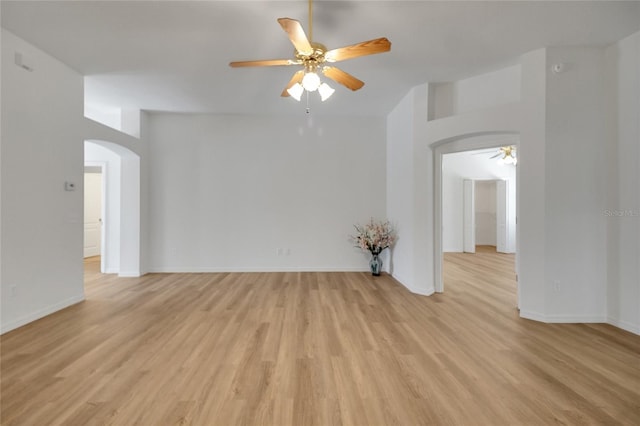 2433 Tamarindo Dr, The Villages, FL 32162 - unfurnished room featuring baseboards, light wood-type flooring, arched walkways, and a ceiling fan