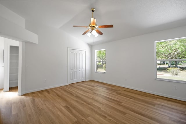 2433 Tamarindo Dr, The Villages, FL 32162 - unfurnished bedroom featuring baseboards, lofted ceiling, wood finished floors, and a ceiling fan