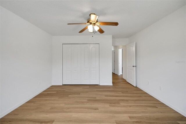 2433 Tamarindo Dr, The Villages, FL 32162 - unfurnished bedroom with baseboards, a closet, light wood-style floors, and ceiling fan