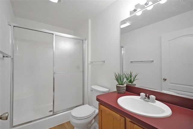 2433 Tamarindo Dr, The Villages, FL 32162 - bathroom with vanity, a textured ceiling, toilet, and a shower stall