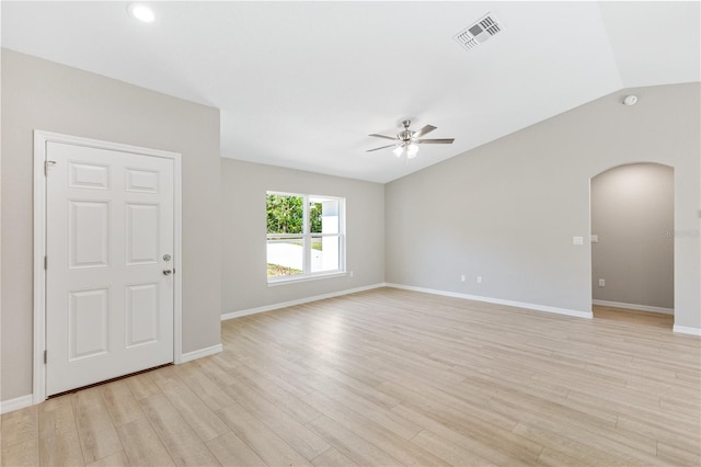 empty room featuring visible vents, arched walkways, ceiling fan, vaulted ceiling, and light wood-type flooring