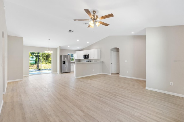 unfurnished living room featuring visible vents, arched walkways, vaulted ceiling, light wood-style floors, and ceiling fan with notable chandelier
