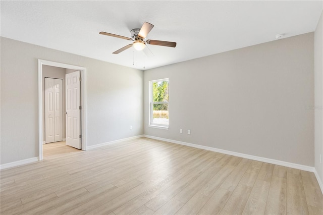 unfurnished room with baseboards, a ceiling fan, and light wood finished floors
