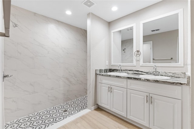 full bath featuring visible vents, a walk in shower, and a sink