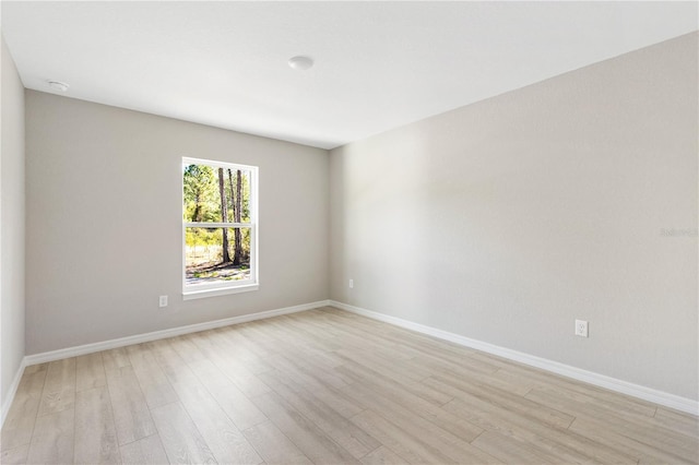 spare room featuring light wood-style flooring and baseboards