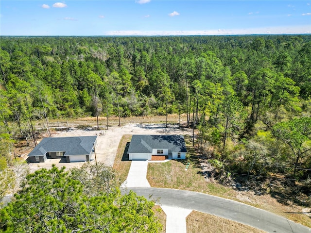 drone / aerial view with a wooded view