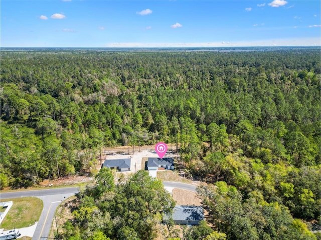 birds eye view of property featuring a wooded view