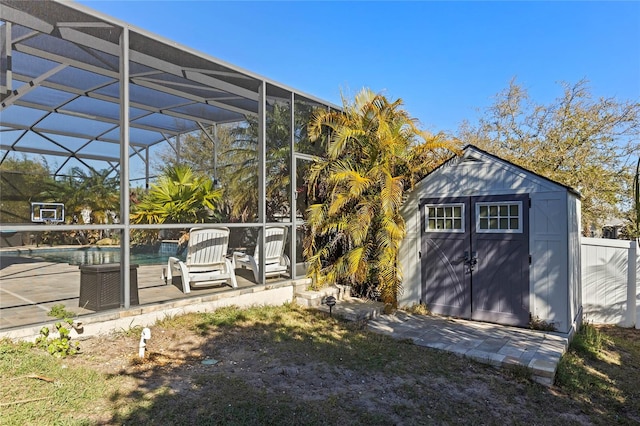 view of yard featuring an outdoor pool, an outbuilding, a shed, glass enclosure, and a patio area