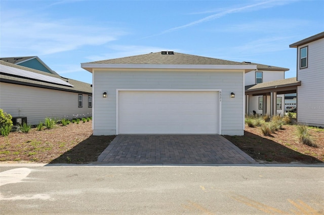 view of front of home featuring decorative driveway and cooling unit