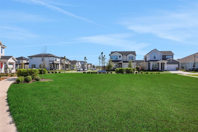 view of community featuring a residential view, a garage, and a yard