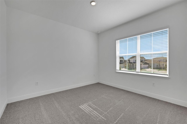 carpeted spare room with baseboards