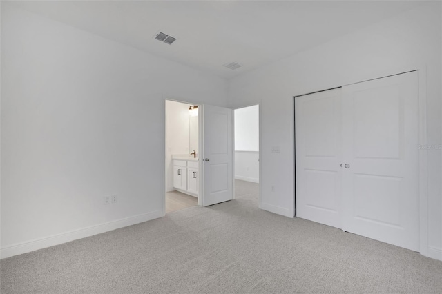 unfurnished bedroom featuring light colored carpet, visible vents, a closet, and baseboards
