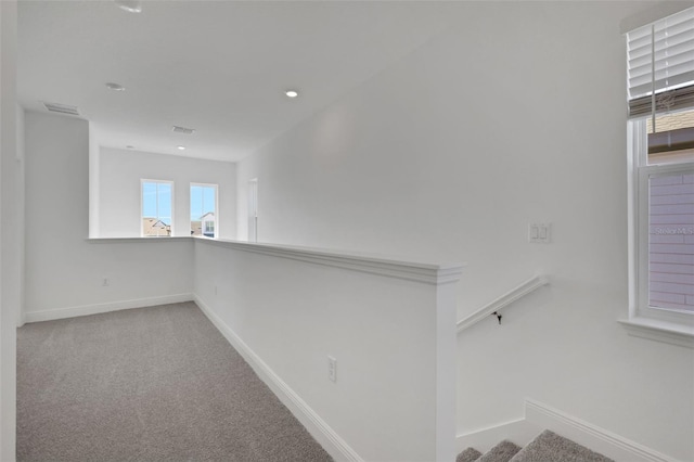 hall featuring baseboards, carpet floors, visible vents, and stairs